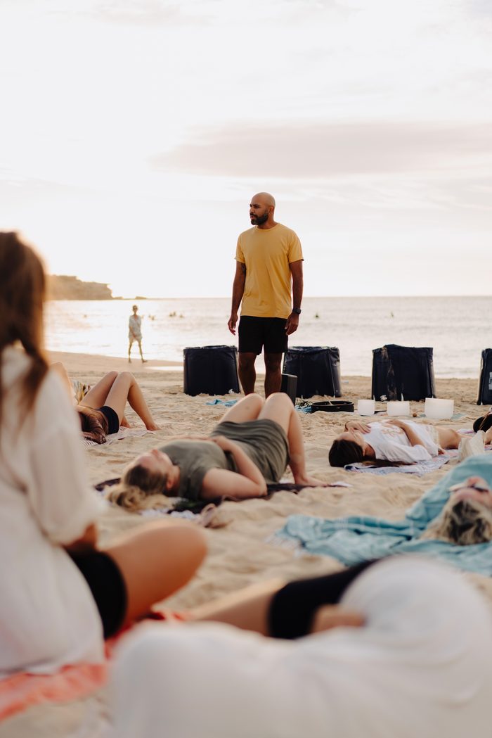 Navjot Matharu, personal development coach, facilitating a sunset breathwork and sound bowl session on Bondi Beach